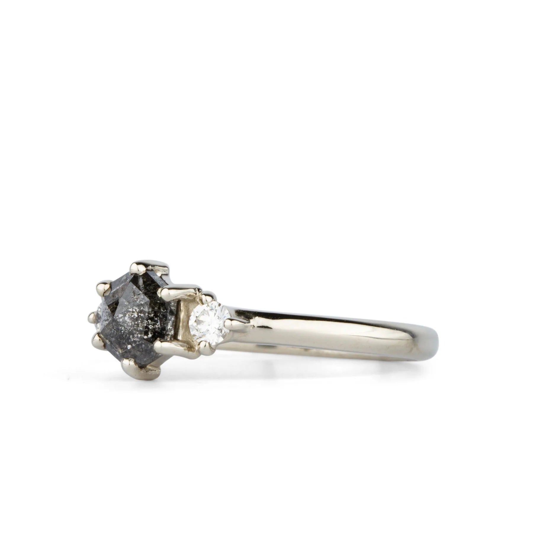 A .77 ct hexagon diamond is the center of this edgy ring as Canadian diamonds flank each side with sparkle.