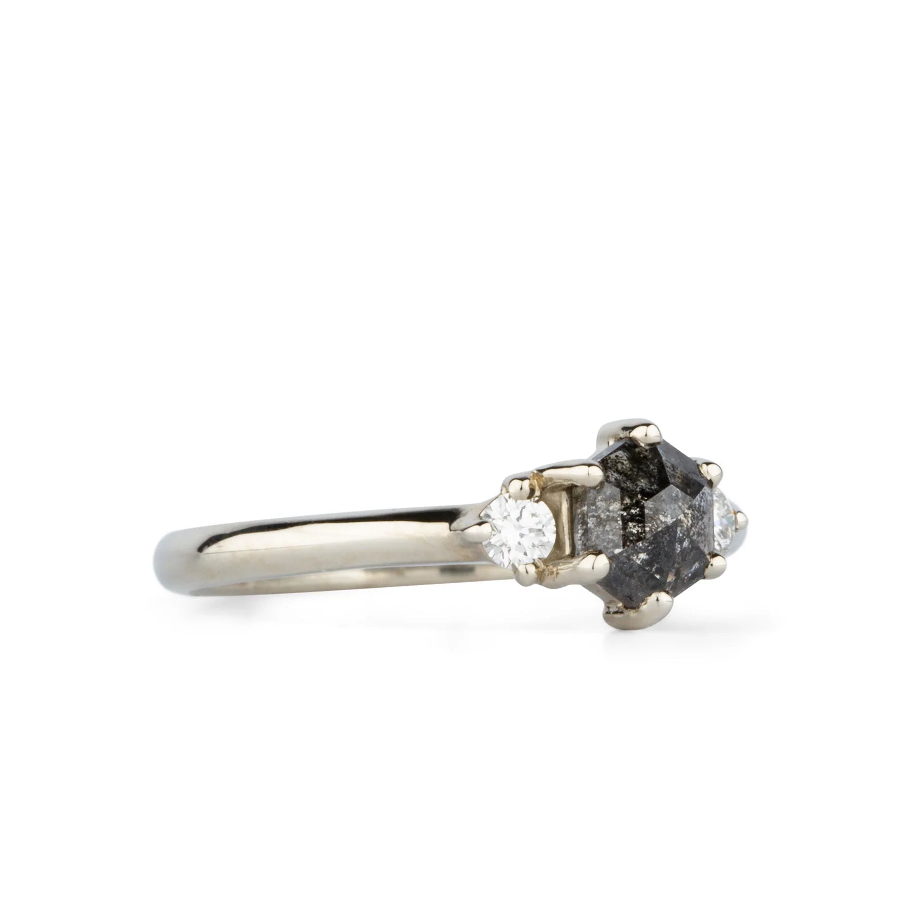 A .77 ct hexagon diamond is the center of this edgy ring as Canadian diamonds flank each side with sparkle.