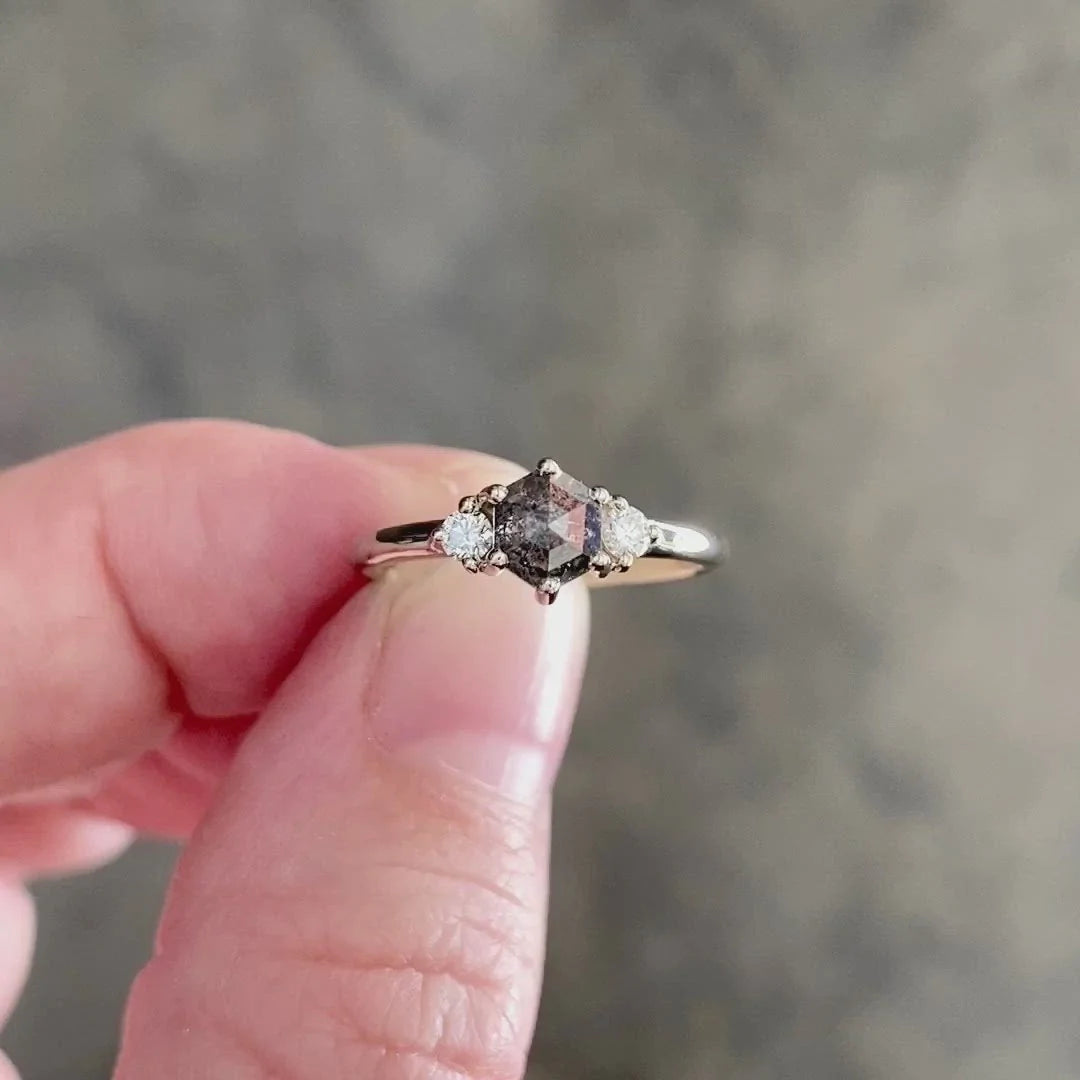 A .77 ct hexagon diamond is the center of this edgy ring as Canadian diamonds flank each side with sparkle held in hand.