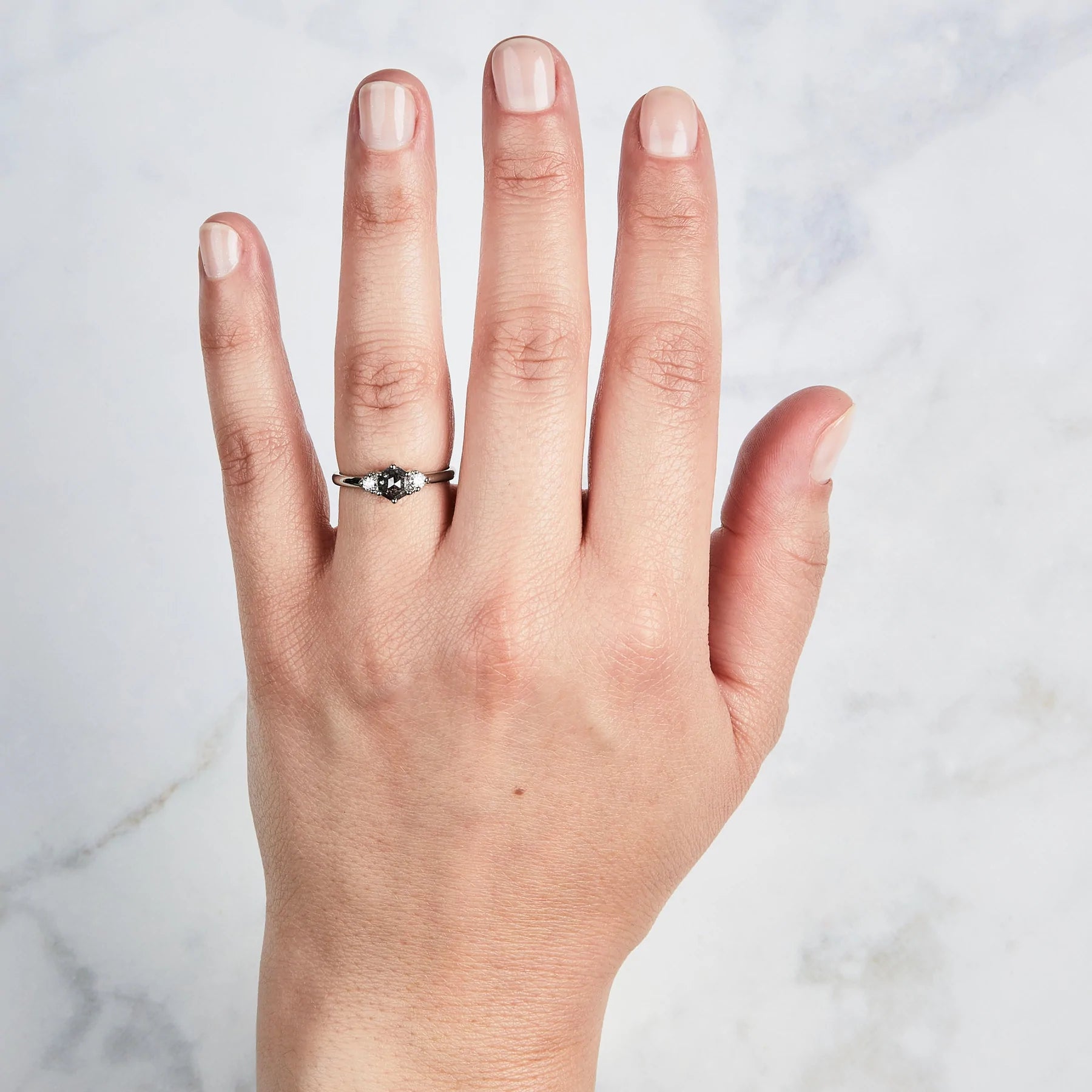 A .77 ct hexagon diamond is the center of this edgy ring as Canadian diamonds flank each side with sparkle on hand